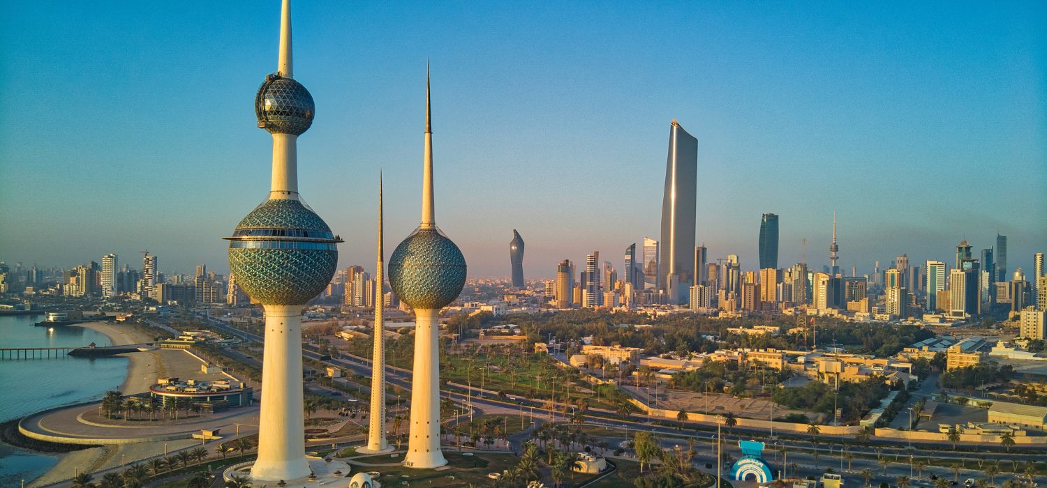 An aerial shot of the Kuwait Towers during sunrise with the view of the skyscrapers at the background