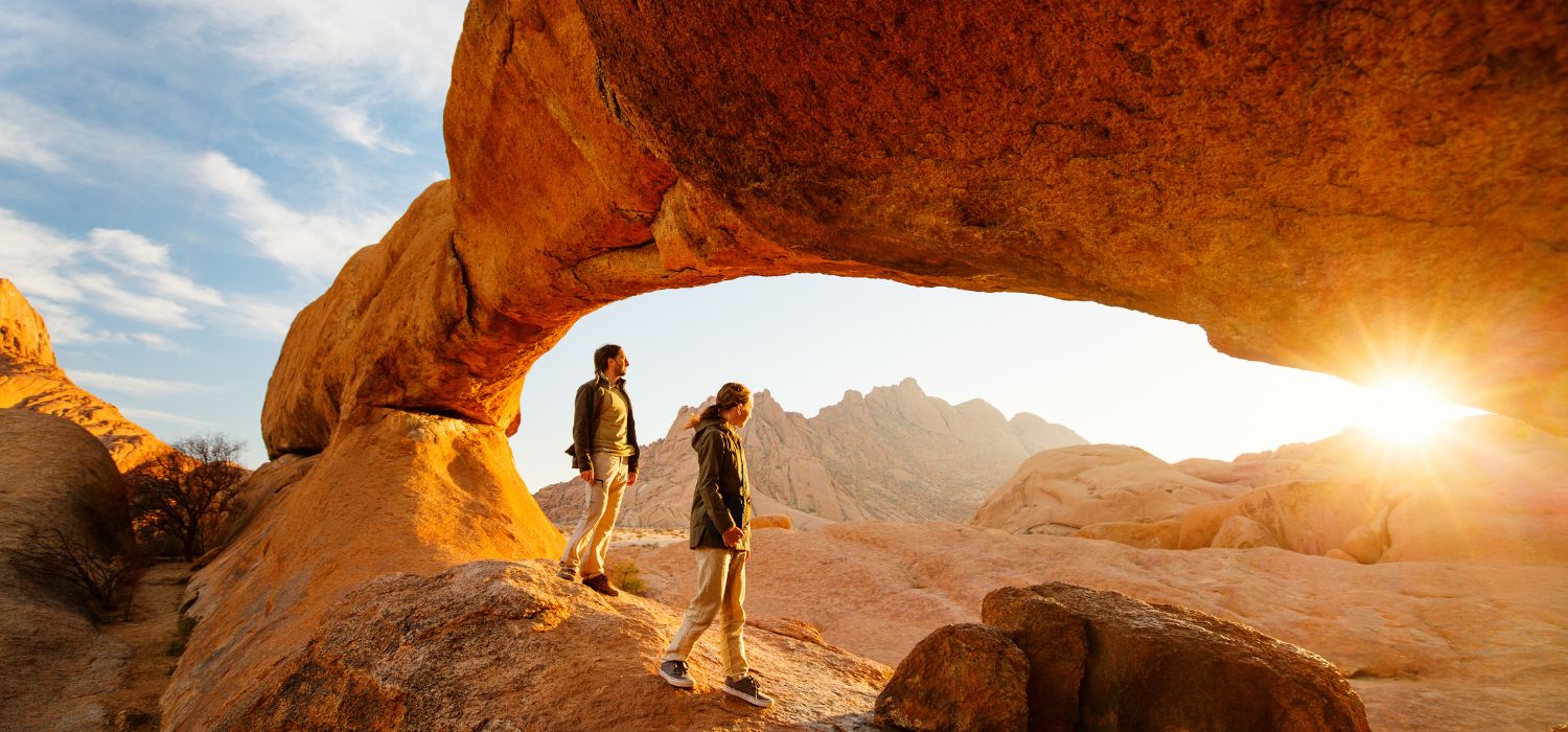 mily father and daughter enjoying sunrise in Spitzkoppe area with picturesque stone arches and unique rock formations in Damaraland Namibia